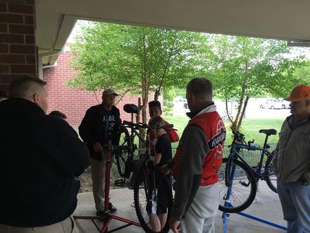 Volunteers and students gathered around bikes in repair stands